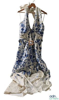 a blue and white dress hanging on a hanger
