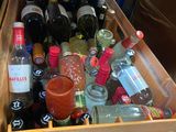 many bottles of alcohol in a wooden box on the floor
