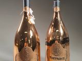 two bottles of champagne sitting next to each other on top of a table