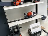 several chainsaws and chainsaws are on a shelf in a garage