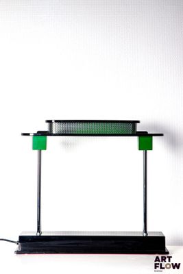 a green lamp that is on top of a black stand