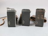 three old cameras sitting next to each other on a table