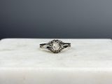 un gros plan d'une bague en diamant posée sur un bloc de marbre