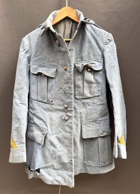 an old jacket hanging on a hanger on a wall