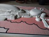 a white sculpture of a motorcycle on a red and white rug