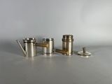 a set of four silver teapots and a teapot on a table