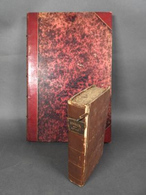 un vieux livre posé sur une table, à côté d'un livre rouge