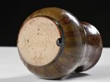 a brown vase sitting on top of a white table