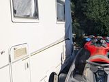 a red atv parked next to a trailer on the side of the road