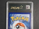 the pokemon card is in a plastic case on a black surface
