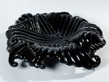 une image représentant un bol noir posé sur une surface blanche