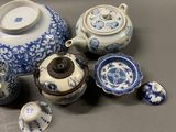several blue and white porcelain teapots and cups on a table