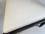 white leather stool with black legs on a white background
