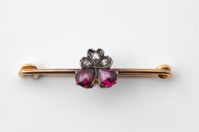 un gros plan d'une broche en forme de fleur rose sur fond blanc