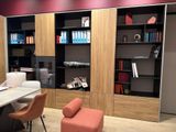 a desk with a chair and a book shelf in the corner