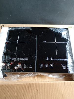 une plaque de cuisson noire dans un carton posé sur une table