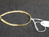Gros plan sur un bracelet en or portant une étiquette