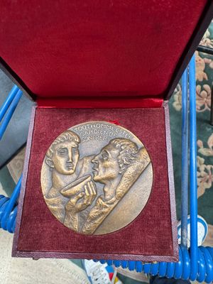 a gold medal in a red box on a blue chair
