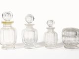 trois bouteilles en verre transparent sont alignées sur une surface blanche