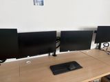 three computer monitors sitting on a desk with a keyboard and mouse