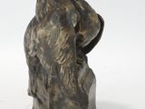 bronze sculpture of a bird perched on a rock on a white background