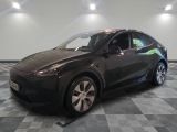 une photo d'une Tesla Model Y noire garée dans un garage