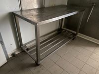 Une table en inox à claies médianes, sur roulettes Dimension…