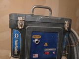 une boîte à outils bleue posée sur des toilettes blanches