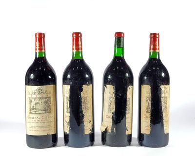 trois bouteilles de vin rouge sont alignées sur une surface blanche