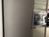 a silver refrigerator in the middle of a room