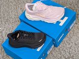 pair of pink and black sneakers in a blue box on the floor