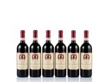 four bottles of red wine are lined up on a white surface