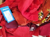 une boîte remplie de t-shirts rouges, sur laquelle est accrochée une étiquette