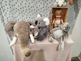 several stuffed animals are sitting on a table with a doll in a box