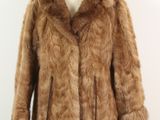 brown fur coat on a mannequin stand against a white wall