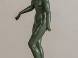 statue of a woman standing on a black base on a wooden table