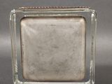 rectangular glass block with a silver base on a grey background