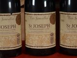 three bottles of wine are lined up on a table