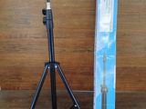 un trépied noir et une boîte bleue posés sur un plancher en bois