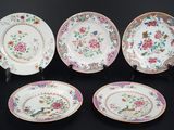 quatre assiettes ornées de motifs floraux sur un fond noir