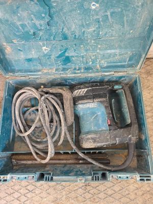 une boîte bleue contenant une perceuse et un cordon