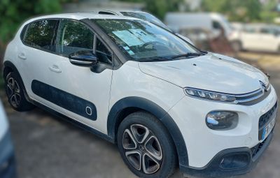 a small white car parked on the side of the road