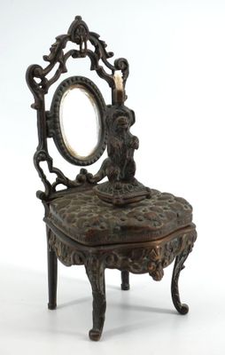 une chaise sur laquelle sont posés un miroir et une bougie