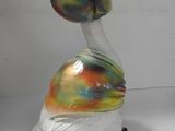 a glass duck with a colorful hat on its head