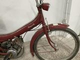 a red motorcycle parked in a room with carpet