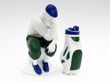 a figurine of a man sitting next to a golf bag