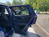 a blue car with its door open in a parking lot