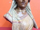 statue d'une femme portant un voile sur la tête, posée sur un fond rouge