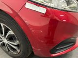 a close up of a red car with a sticker on it