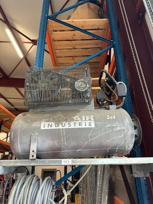a large air compressor sitting on a shelf in a warehouse